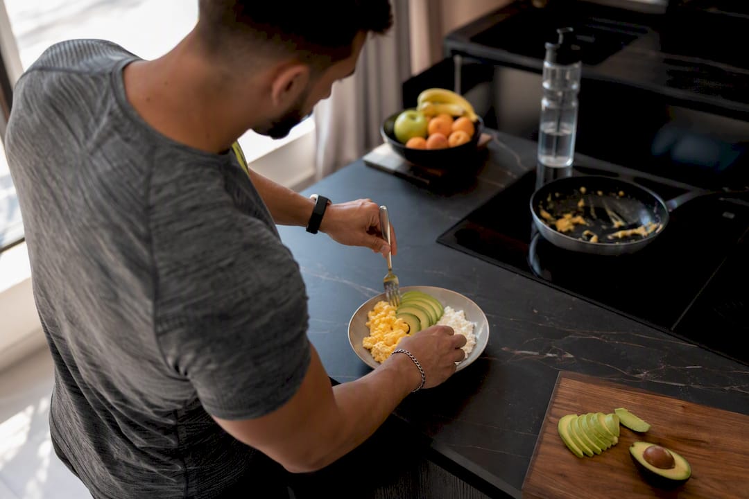 Mains préparant une assiette de petit-déjeuner riche en protéines