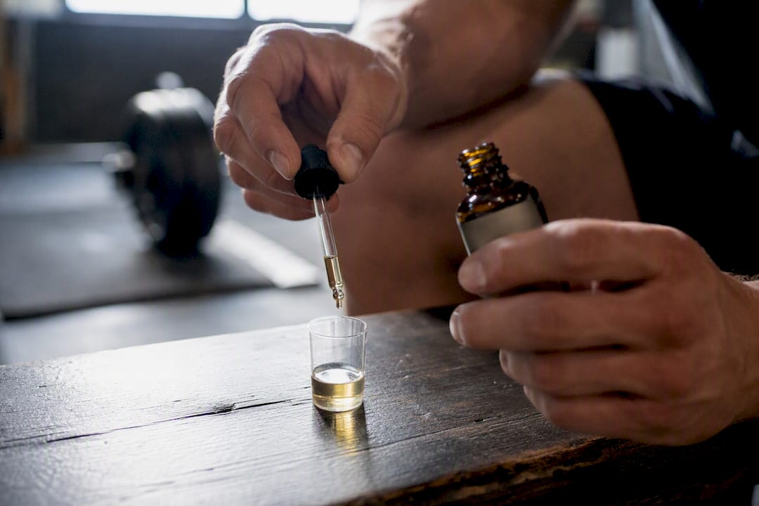 Athlète versant un complément d'huile de vitamine D3