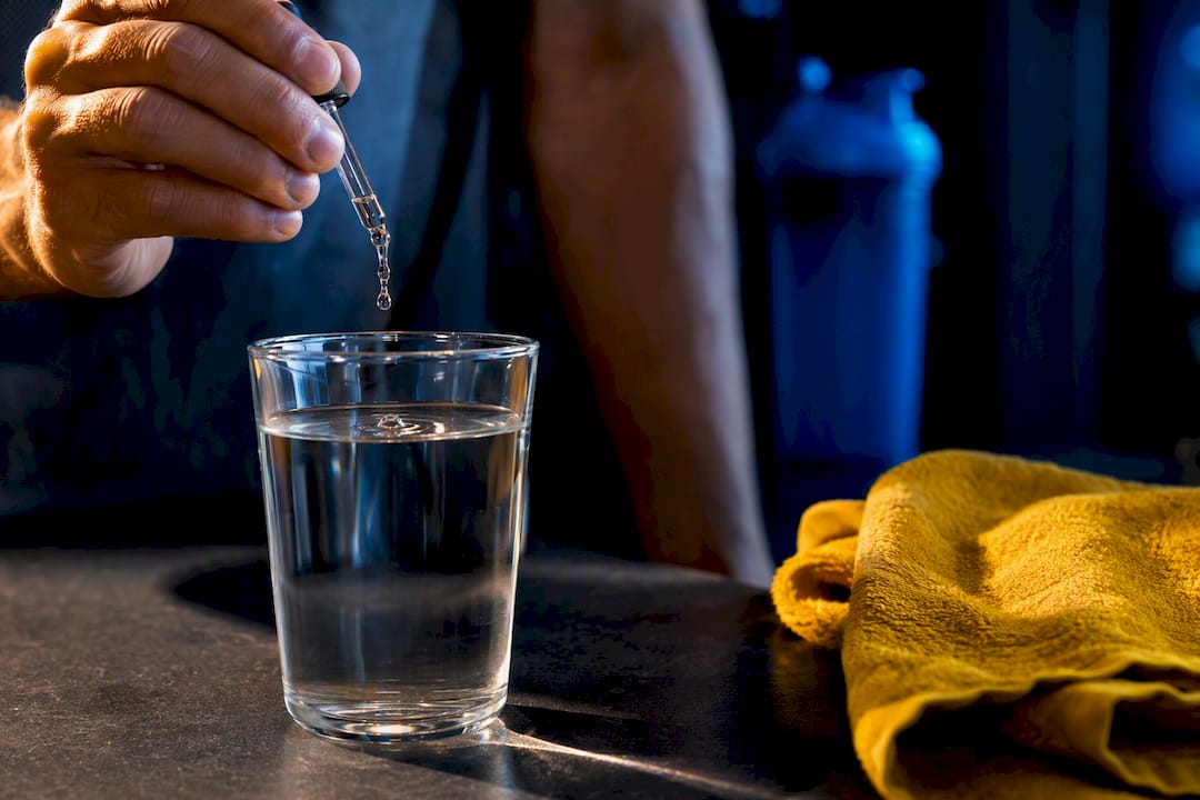 Versement de vitamine C liquide dans un verre